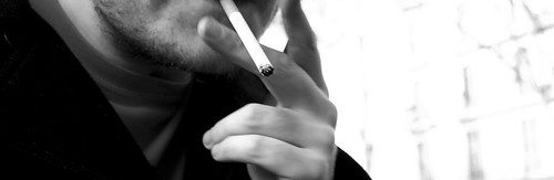 chico fumando un cigarro blanco negro