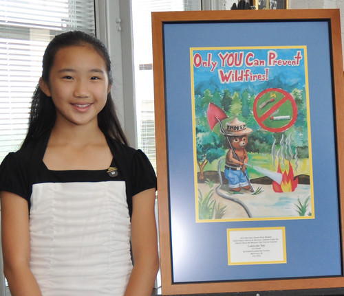 Caroline Tan, 11, of Westfield, N.J., poses with the poster that earned her the title of national winner in the Smokey Bear & Woodsy Owl Poster Contest. Photo credit Dominic Cumberland/U.S. Forest Service 