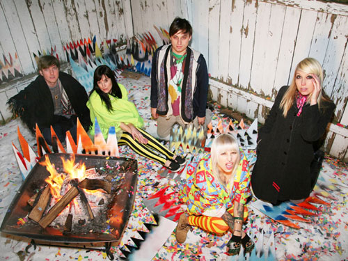 members of tilly and the wall sitting around a colorful cardboard campfire