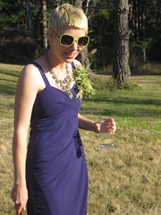Michael standing in a purple dress, holding a cocktail