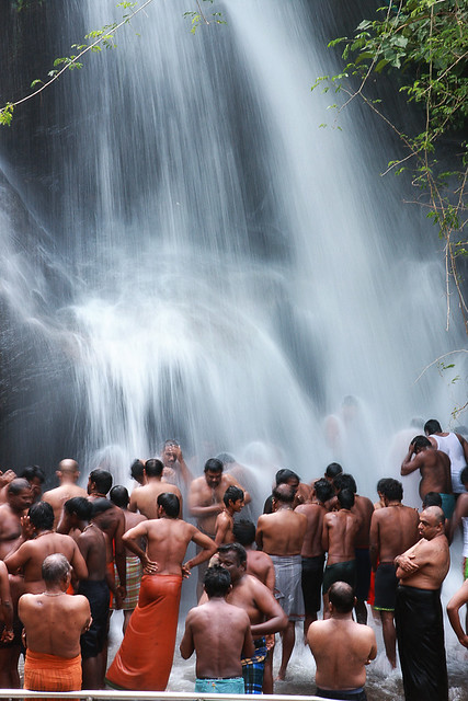 Devotees taking bath in the waterfall Kutralam