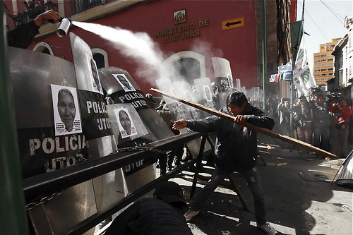 A police officer uses pepper spray on an Amazon Indian man camped several days near the presidential palace to protest a road that President Evo Morales plans to build through a nature reserve.