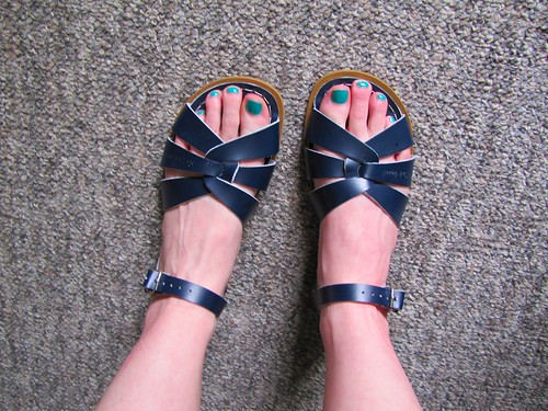 navy saltwater sandals with feet inside