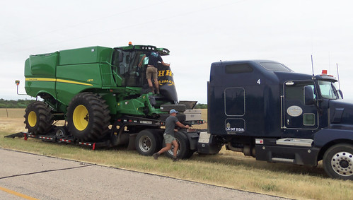 Oak removes the windshield guard while Montana works on helping to get ready to unload the combine
