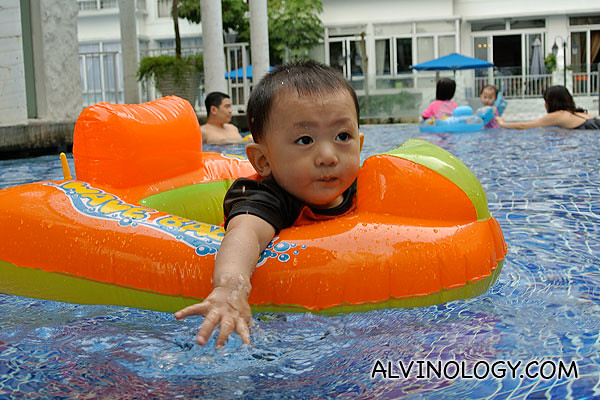 Asher paddling on his own in a float