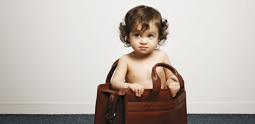 white baby sitting in a briefcase