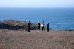long-distance shot of Michael and her partner at their wedding, standing on a cliff in the sun