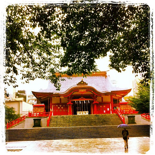 I am standing in front of Hanazono Shrine while it rains heavily.