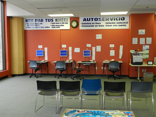 Robles computer wall with self-service signs in Spanish and Hmong. Established in the 1970’s, the Robles Center located in Milwaukee Wisconsin, was the first social services office serving Milwaukee’s predominantly Latino south side. 