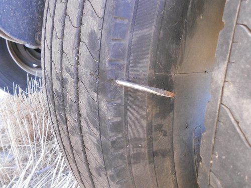 Part of a screw driver through the grain trailer tire