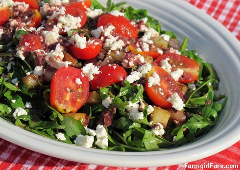 recipe: arugula salad with pan-fried herbed potatoes, cherry tomatoes, feta cheese & kalamata olive vinaigrette