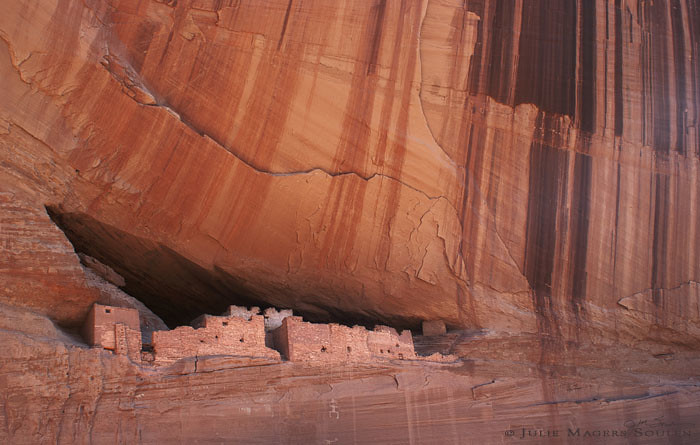 Southwestern cliff dwelling, of an ancient prehistoric pueblo of the Anasazi in the American southwest nestled into a towering red rock cliff.