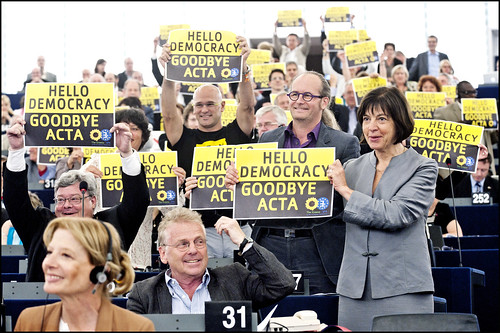 MEPs from the Greens/EFA group hold up a sign saying "Hello Democracy, Goodbye ACTA" by European Parliament