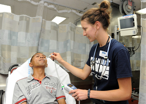Registered Nurse Molly Tarvik, Project Hope volunteer, checks an Indonesian patient’s body temperature