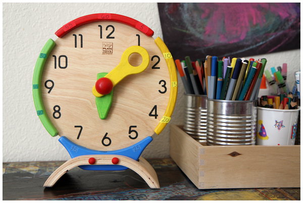 Teaching kids to tell time with the wooden Plan Toys Activity Clock