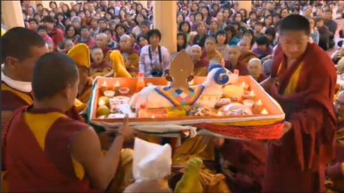The sangha watches monks carry a traditional Tibetan Buddhist ram shaped torma offering outside, mandala offering, After His Holiness the Great 14th Dalai Lama  bestowed Medicine Buddha initiation via the Internet, teaching, Dharamsala, India by Wonderlane
