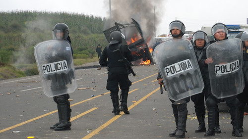 National Civil Police agents stand near a military truck in flames during clashes with peasants protesting against the cost of electricity in Santa Catarina Ixtahuacan, west of Guatemala City on Thursday Oct. 4, 2012. by Pan-African News Wire File Photos