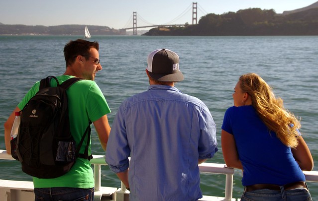 Tourists enjoying Sausalito to San Francisco ferry ride, Golden Gate Bridge in background