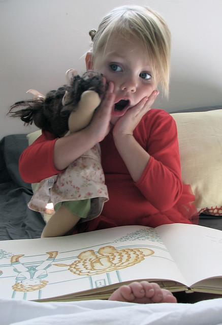 girl reading to her doll