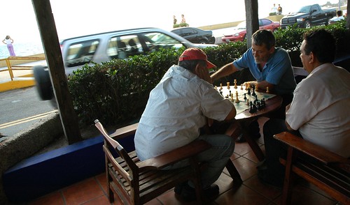 Men playing  a chess game on the sidewalk, vehicles, people walking by, South Mazatlan, Sinaloa, Mexico by Wonderlane
