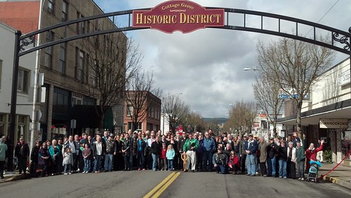 Cottage Grove residents stand under an arch welcoming visitors to the newly restored downtown area.  