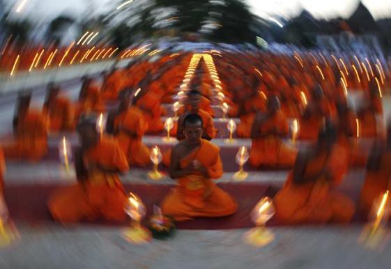 Buddhists monks pray at a temple in Suphan Buri province