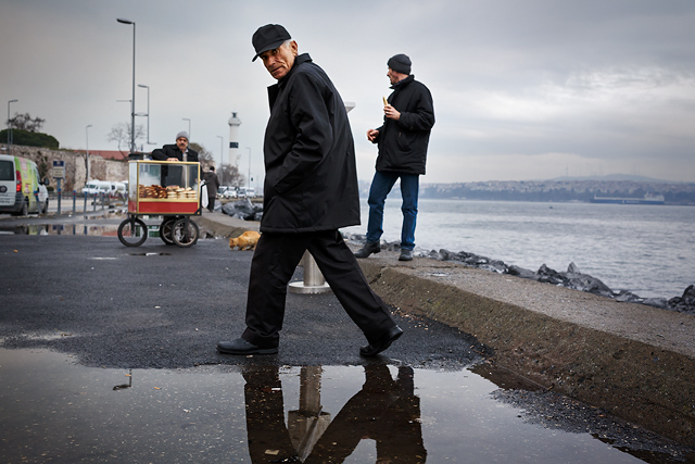 Turkish man stepping over a puddle in Istanbul.