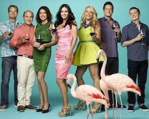 The cast of Cougar Town holding glasses of red wine.