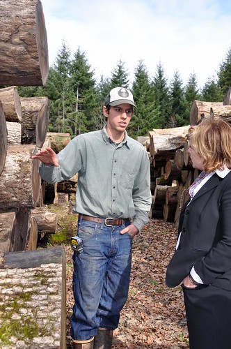 Ben Deumling (left) explains to USDA’s Lillian Salerno the uses and values of different sizes of sustainably harvested Oregon white oak.
