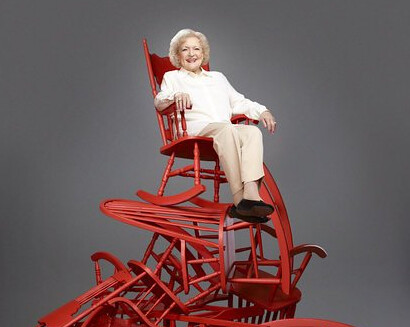 Betty White sitting on a pile of chairs
