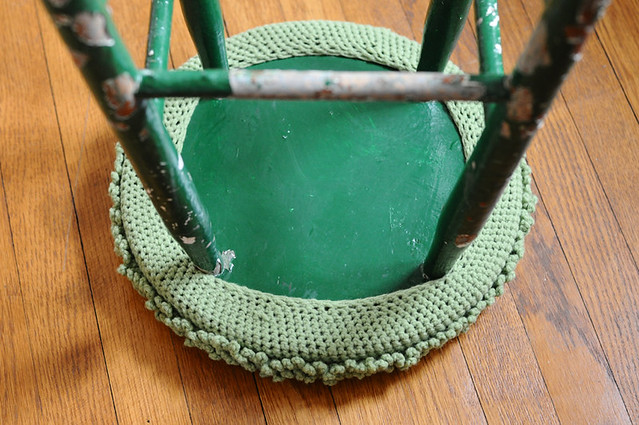 green crocheted stool cover