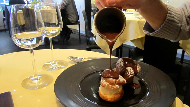 Pouring chocolate over profiteroles