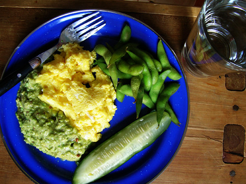 scrambled eggs and guacamole, edamame, pickle, and water