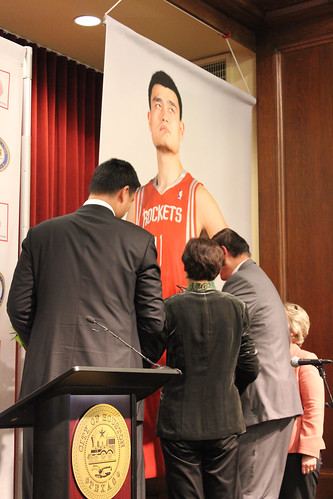 February 15th, 2013 - Yao Ming and his parents sign a poster of Yao in a Rockets uniform