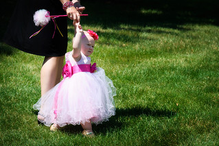 Toddler flower girl in a cute pink dress walking with her mother during a 2012 wedding