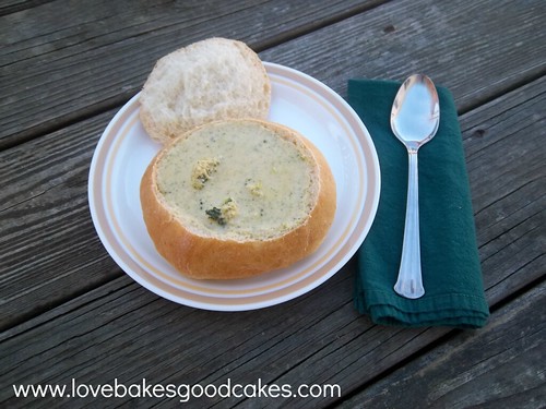 Broccoli and Cheese Soup in Homemade Bread Bowl on plate with spoon and napkin.