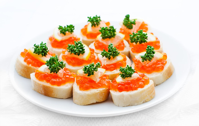 Canapes with salmon caviar, lemon and parsley