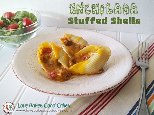 Enchilada Stuffed Shells on plate with fork, and green salad with tomatoes.
