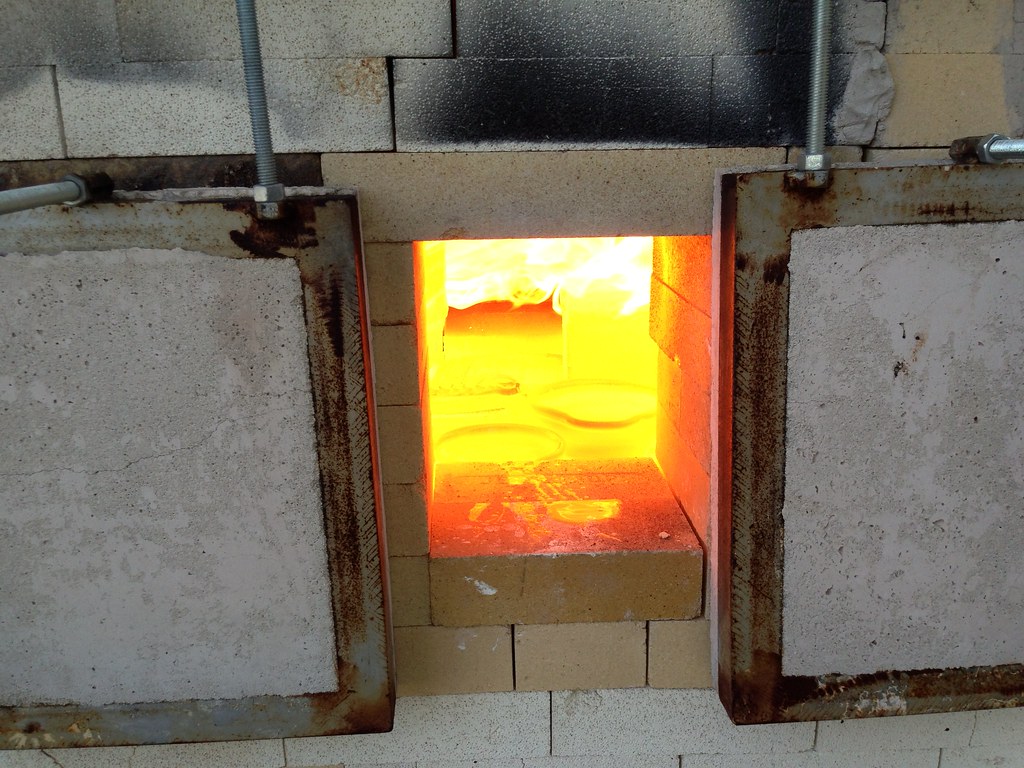 Looking in the kiln near peak temperature. You can sort of see the rims of the crucibles holding colored glass.