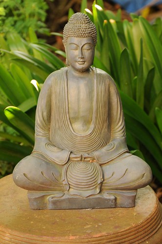 Formal folds of his garment, Lord Buddha meditates, inquiring within, statue on a platform, garden, South Bay Vajrayana, Cupertino, California, USA by Wonderlane