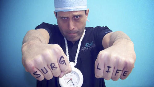 Salzhauer holding his fists out to read SURG LIFE on his knuckles
