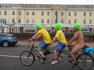 three guys on a tandem with green mankini wearer on back