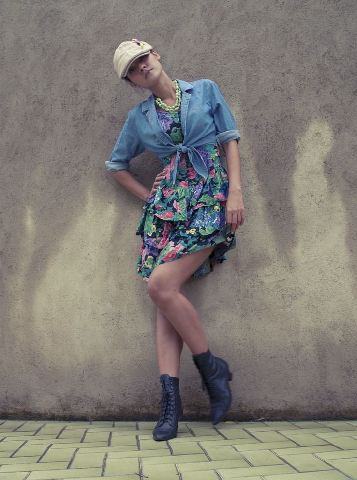 She's got spunk! 1980s mini floral dress with tiers, worn with a denim cropped shirt tied above the waist. Bright accessories and ankle boots complete the look.  