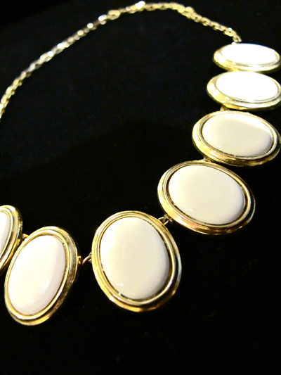 Pretty choker made out of white oval shaped discs and gold accents