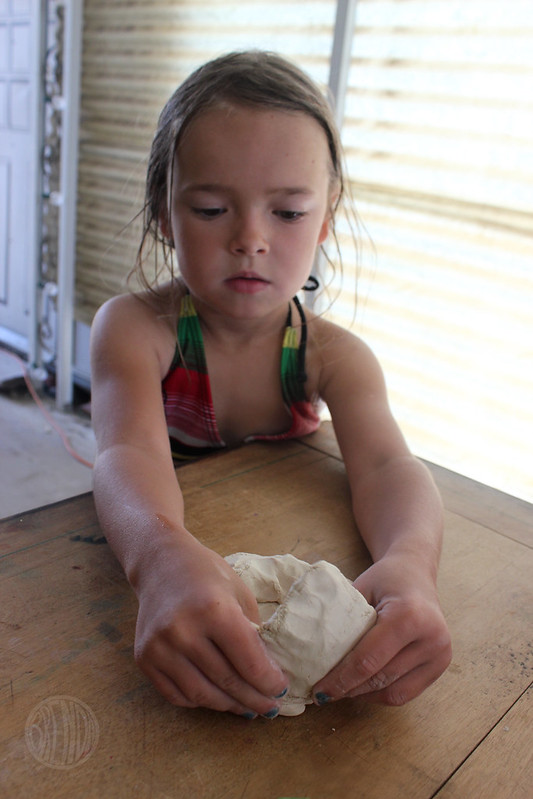 Child forming a monster head with clay