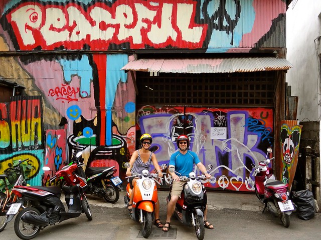 Mom and dad on motorbikes with street art