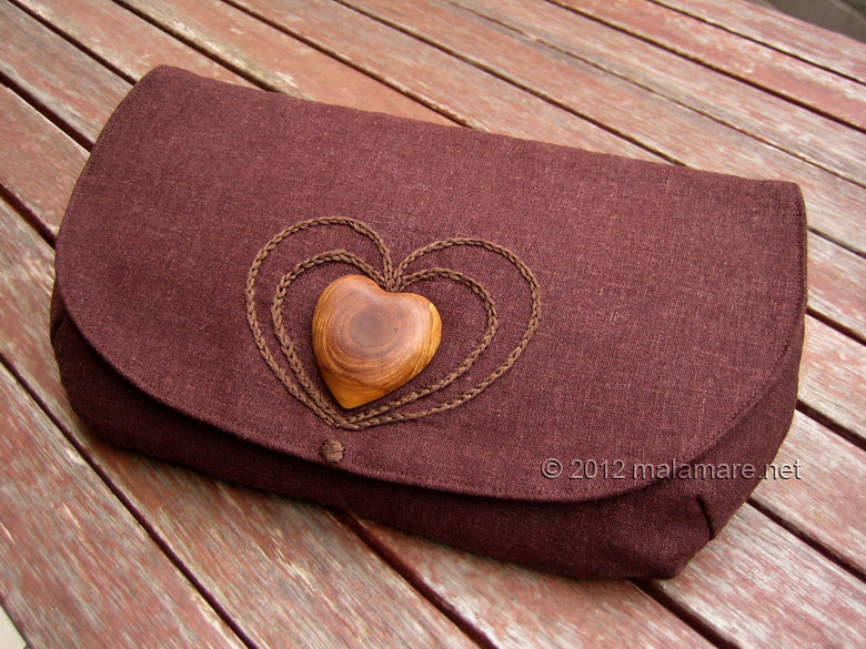 brown linen fabric clutch bag with olive wood heart and hand embroidered heart motif