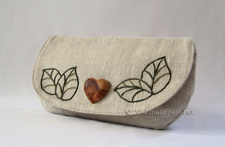 natural linen fabric clutch bag with olive wood heart and hand embroidered leaves motif