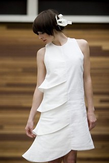 a woman in an asymmetrical white dress