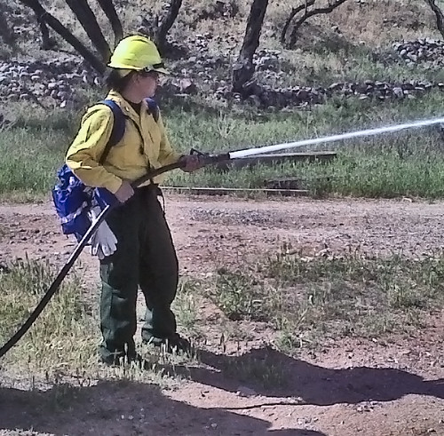 A boot camp participant learns how to use a fire hose.